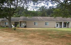 Reedport apartment for rent - a brown house with a yard and a tree