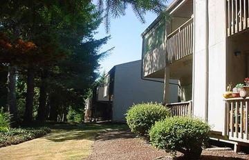 Lincoln City apartment for rent - the side of a house with trees and bushes