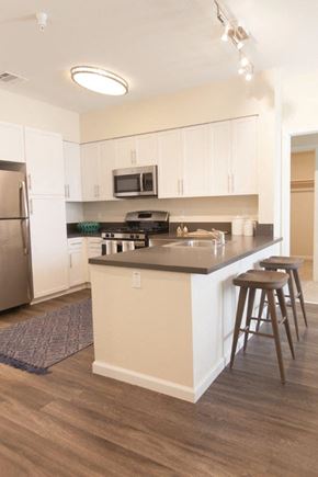 Elk Grove apartment for rent - A kitchen with white cabinets and a black stove top.