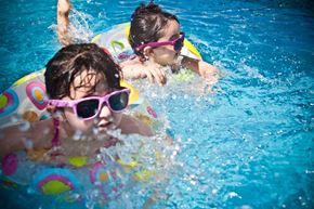 Elk Grove apartment for rent - Two children wearing pink sunglasses are swimming in a pool.