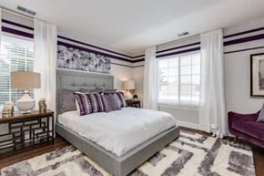 Auburn Hills apartment for rent - A bedroom with a large bed and a purple chair.
