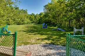 Auburn Hills apartment for rent - A green fenced area with a playground and trees in the background.