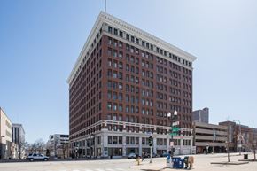 Peoria apartment for rent - a tall red brick building with many windows on a city street