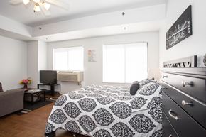 Peoria apartment for rent - a bedroom with a bed and a dresser and a tv