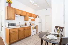 Peoria apartment for rent - a kitchen with wooden cabinets and a dining table