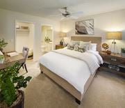 Irvine apartment for rent - Model living room featuring a bed with a white duvet at Woodbridge apartments in Irvine.