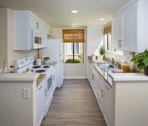 Irvine apartment for rent - Model kitchen area with white cabinets at Woodbridge apartments in Irvine.