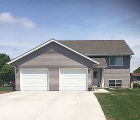 Belle Plaine townhouse for rent - a house with two garage doors on the side of a driveway