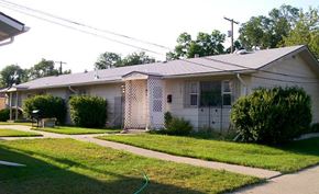 Billings triplex for rent - a white house with a yard and a sidewalk