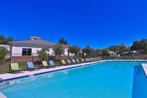 Baltimore townhouse for rent - a large swimming pool with chairs in front of a house