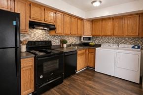 Baltimore townhouse for rent - A kitchen with black appliances and wooden cabinets.
