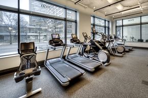 Chicago apartment for rent - a gym with cardio equipment and large windows at the district flats apartments