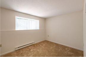 Lowell apartment for rent - an empty bedroom with a window and a carpeted floor