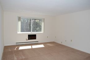Lowell apartment for rent - an empty living room with a window and white walls