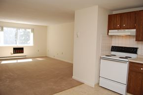 Lowell apartment for rent - an empty kitchen with a stove and a window