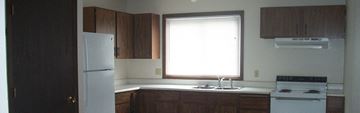 Missoula apartment for rent - a kitchen with white appliances and wooden cabinets