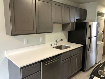 Everett apartment for rent - A kitchen with a black refrigerator and stainless steel appliances.