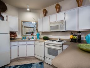 Stillwater apartment for rent - a kitchen with white cabinets and a white stove and microwave