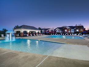 Stillwater apartment for rent - a swimming pool at night with apartments in the background