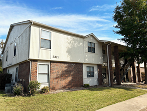 Rogers apartment for rent - a side view of an apartment building with a lawn