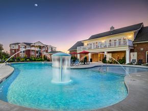 Stillwater apartment for rent - a large swimming pool with a fountain in front of a house