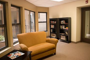 St. Paul apartment for rent - a living room with a yellow chair and a book shelf