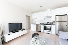 San Francisco apartment for rent - a living room with a tv and a kitchen with stainless steel appliances