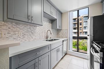 Los Angeles multi-family for rent - a kitchen with white cabinets and a window