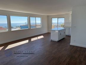 San Pedro apartment for rent - an empty living room with a kitchen and a view of the ocean