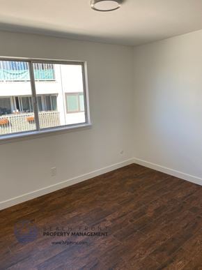San Pedro apartment for rent - an empty room with wooden floors and a window