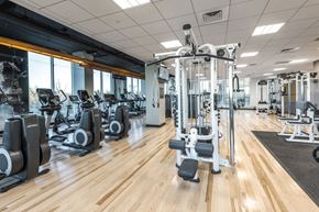 Denver apartment for rent - a gym with cardio machines and weights on a wooden floor