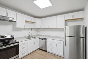Denver apartment for rent - A kitchen with white cabinets and a stainless steel refrigerator.