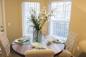 Broomfield apartment for rent - a dining room with a table and chairs and a vase with flowers
