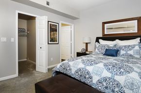 Denver apartment for rent - A bedroom with a large bed and a painting on the wall.