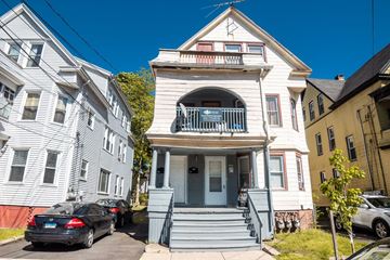 New Haven apartment for rent - A white house with a blue door and a balcony.