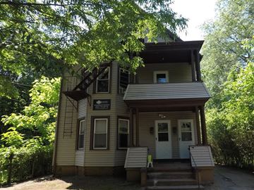 New Haven apartment for rent - A house with a porch and a tree in front.