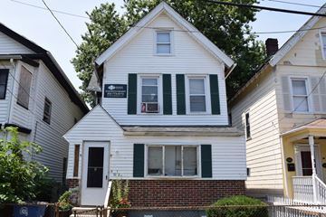 New Haven apartment for rent - A white house with green shutters and a sign that says "For Sale".