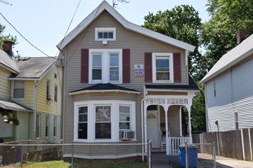 New Haven apartment for rent - A two-story house with a front porch and a sign on the front window.