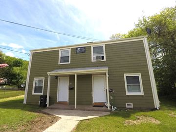 New Haven apartment for rent - A small green building with a white door and windows.