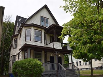 New Haven apartment for rent - A house with a brown roof and white walls with a balcony.