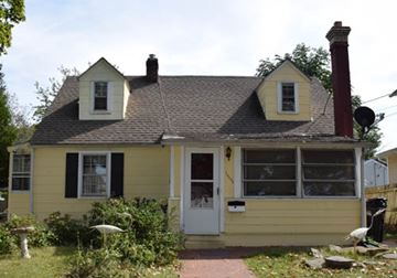 New Haven apartment for rent - A small yellow house with a white door and a chimney.