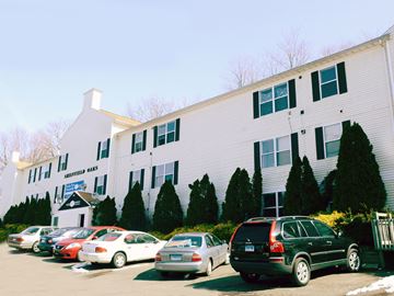 New Haven apartment for rent - A white building with a sign that says "Skippers Ales" in front of a parking lot.