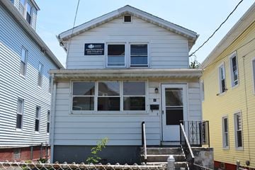 New Haven apartment for rent - A two-story house with a white exterior and a black door.