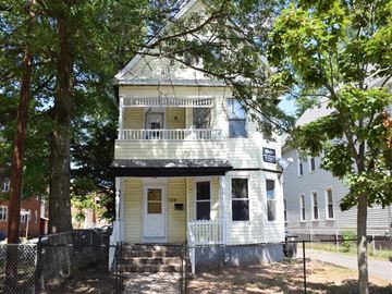 New Haven apartment for rent - A white two-story house with a porch and a tree in front.