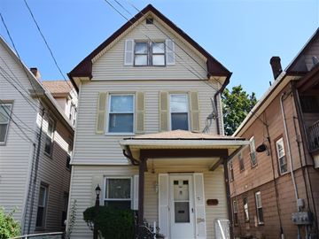 New Haven apartment for rent - A house with a white door and windows is surrounded by other houses.