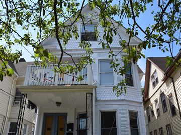 New Haven apartment for rent - A white house with a balcony and a blue door.