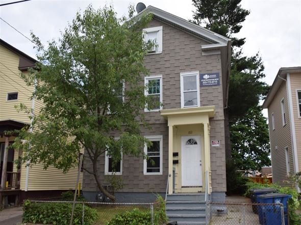New Haven apartment for rent - A grey house with a white door and a tree in front.