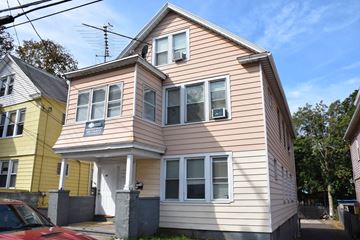New Haven apartment for rent - A two-story house with a red car parked in front.