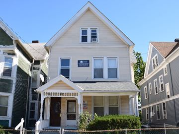 New Haven apartment for rent - A white house with a brown door and a sign on the front.