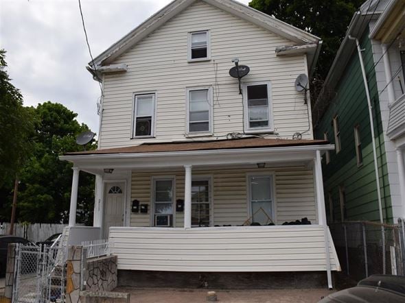New Haven apartment for rent - A white house with a porch and a satellite dish on the roof.
